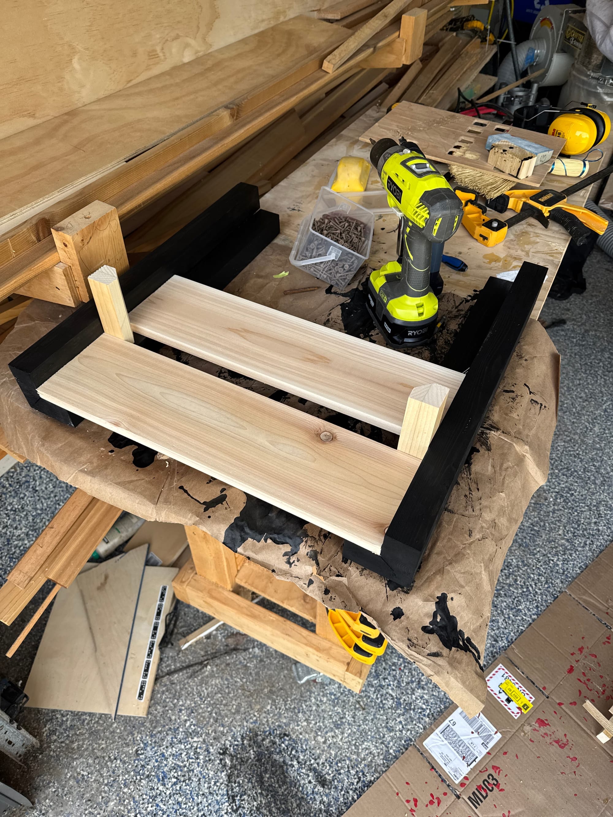 Picture of the side of the deck box lying on its side with some scraps of wood spacing the slats. 
